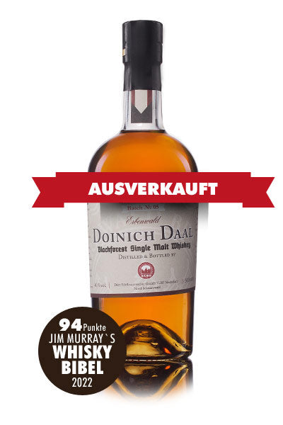 Das Bild zeigt eine ausverkaufte Flasche Doinich Daal Blackforest Single Malt Whisky, die in Jim Murrays Whisky Bibel 2022 mit 94 Punkten bewertet wurde.
Das Bild zeigt eine einzelne Flasche Doinich Daal Blackforest Single Malt Whisky im Vordergrund. Die Flasche ist aus Glas, mit einer goldbraunen Flüssigkeit gefüllt, die den Whisky darstellt. Der Flaschenhals ist mit einem schwarzen Verschluss versehen. Das Etikett ist cremefarben mit brauner Schrift und zeigt den Namen "Doinich Daal", den Untertitel "Blac