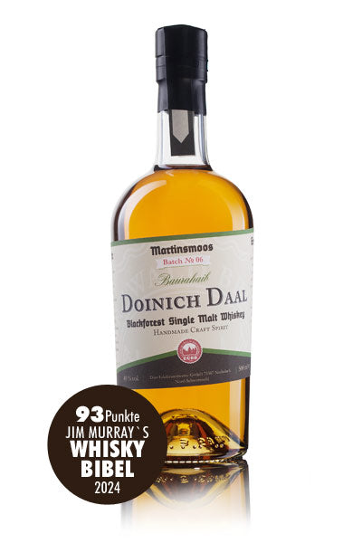 Das Bild zeigt eine Flasche Doinich Daal Blackforest Single Malt Whiskey, die von Jim Murrays Whisky Bibel 2024 mit 93 Punkten bewertet wurde.
Das Bild zeigt eine einzelne Flasche Doinich Daal Blackforest Single Malt Whiskey aus der Brennerei Martinsmoos, Charge Nr. 06, Baurahaib. Die Flasche ist aus klarem Glas und enthält eine goldgelbe Flüssigkeit. Sie hat einen schwarzen Verschluss und ein Etikett mit beige-braunen Farbtönen. Das Etikett zeigt den Namen der Marke und des Whiskys, den Hinweis auf Single