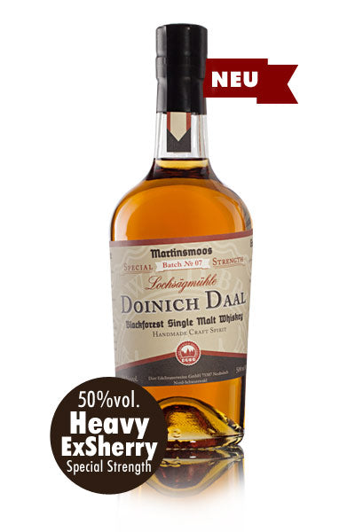 Das Bild zeigt eine Flasche Doinich Daal Blackforest Single Malt Whiskey.
Das Bild zeigt eine einzelne Flasche Doinich Daal Blackforest Single Malt Whiskey aus der Brennerei Martinsmoos, Charge Nr. 07, Lochsägmühle. Die Flasche ist aus klarem Glas und enthält eine goldgelbe Flüssigkeit. Sie hat einen schwarzen Verschluss und ein Etikett . Das Etikett zeigt den Namen der Marke und des Whiskys, den Hinweis auf Single Malt Whiskey aus dem Schwarzwald, sowie "Handmade Craft Spirit". Im unteren Teil des Etiketts