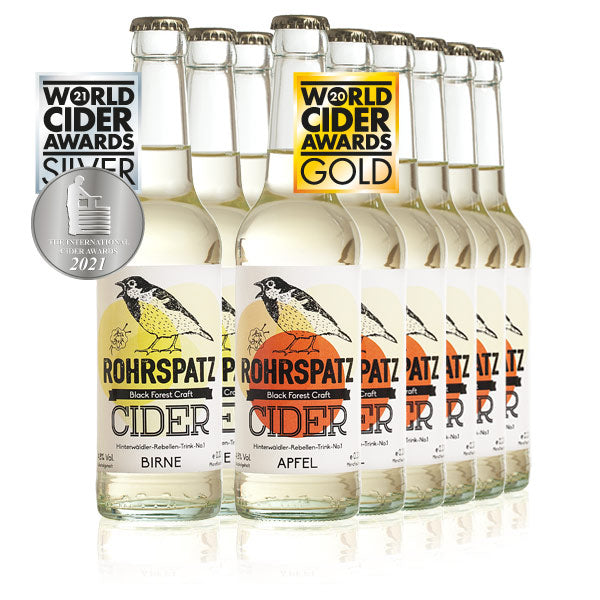 Das Bild zeigt meherere Flasche Rohrspatz Apfel-Cider und zeigt mehrere Flasche Rohrspatz Birne Cider.
Das Bild zeigt rechts mehrere Flaschen Rohrspatz Apfel Cider im Vordergrund, auf weißem Hintergrund. Die Flaschen sind aus Glas, klar und zylindrisch geformt und mit einer hellgelben Flüssigkeit gefüllt. Das Etikett ist weiß mit einem orangefarbenen Kreis im Hintergrund, auf dem ein stilisierter, singender Vogel abgebildet ist. Der Name „ROHRSPATZ“ ist in großen, schwarzen Buchstaben auf dem Etikett zu le
