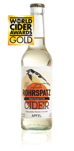 Das Bild zeigt eine Flasche Rohrspatz Apfel-Cider, die mit einer Goldmedaille der World Cider Awards ausgezeichnet wurde.
Das Bild zeigt eine einzelne Flasche Rohrspatz Apfel Cider im Vordergrund, auf weißem Hintergrund. Die Flasche ist aus Glas, klar und zylindrisch geformt mit einem leicht konischen Hals. Sie ist bis zum Hals mit einer hellgelben Flüssigkeit gefüllt. Das Etikett ist weiß mit einem orangefarbenen Kreis im Hintergrund, auf dem ein stilisierter, singender Vogel abgebildet ist. Der Name „ROHR